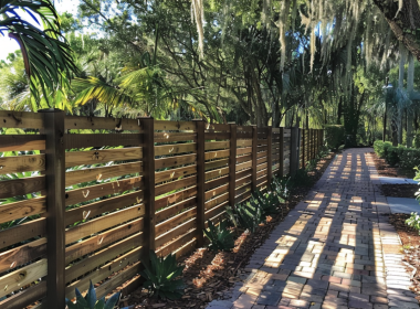 A walkway with a wooden fence and trees.