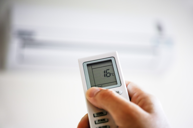 Human hand using remote control of air conditioner