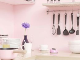 a pink kitchen with utensils hanging on the wall