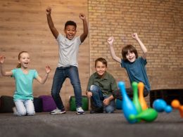 Full shot smiley kids playing bowling