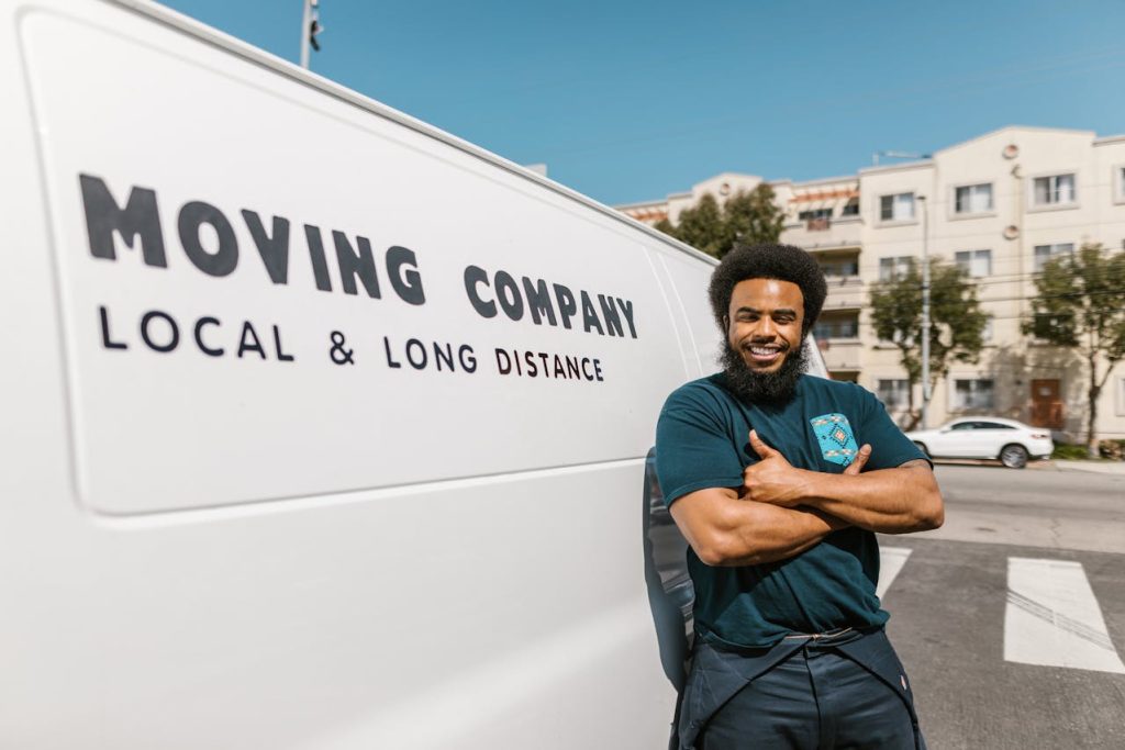 Man standing beside a white moving company van.