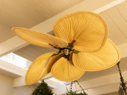 Close-up of decorative ceiling fan with leaf-shaped blades in modern home, copy space. Interior, design, furnishing, luxury, contemporary, stylish