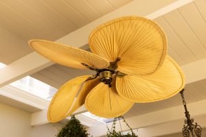 Close-up of decorative ceiling fan with leaf-shaped blades in modern home, copy space. Interior, design, furnishing, luxury, contemporary, stylish