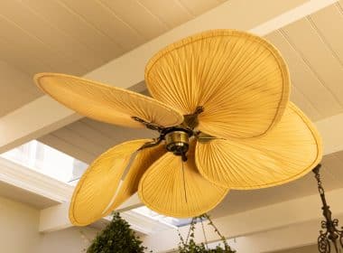 Close-up of decorative ceiling fan with leaf-shaped blades in modern home, copy space. Interior, design, furnishing, luxury, contemporary, stylish