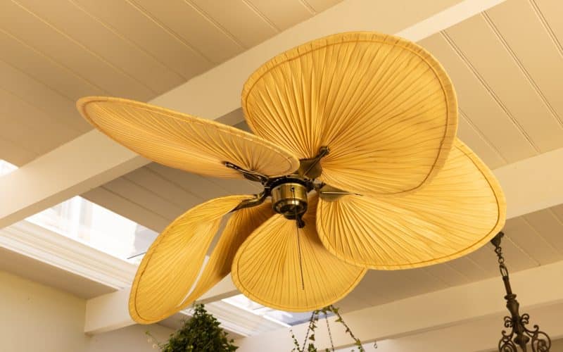 Close-up of decorative ceiling fan with leaf-shaped blades in modern home, copy space. Interior, design, furnishing, luxury, contemporary, stylish