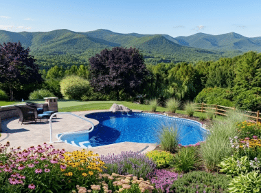 A beautiful pool with a landscaped garden and mountain range in the background.